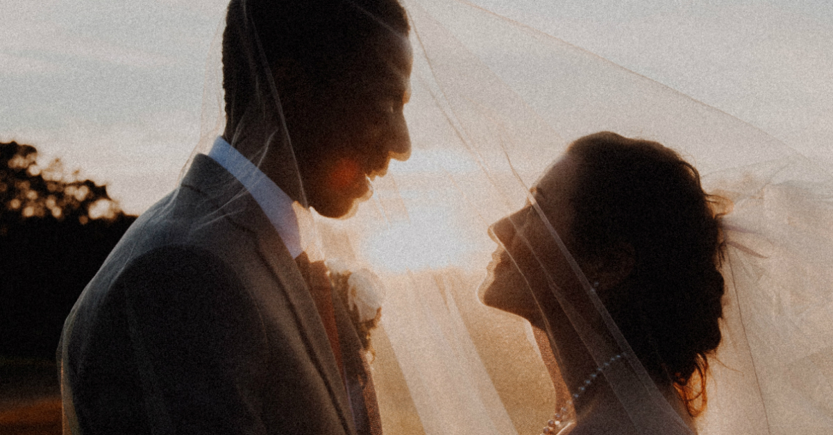 wedding couple looking at each other under a veil happy, ready to marry