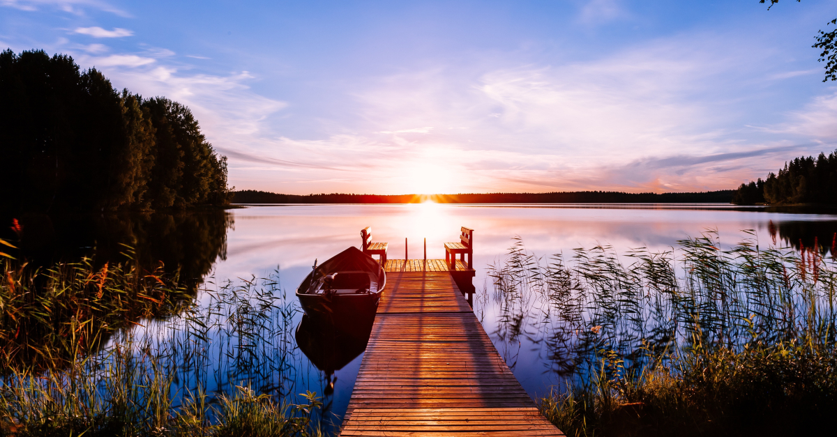 canoe by dock at sunset on lake